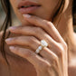 Model wearing 10k yellow gold oval cut lab diamond pave engagement ring with eternity band touching face