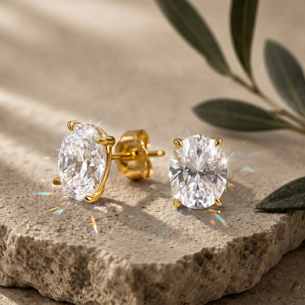 10k yellow gold 4x6mm oval shape lab diamond stud earrings on stone texture surface with green leaf