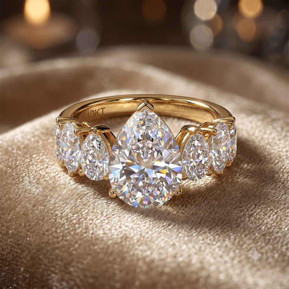 10k yellow gold pear shape lab diamond five-stone ring displayed on luxurious gold satin fabric