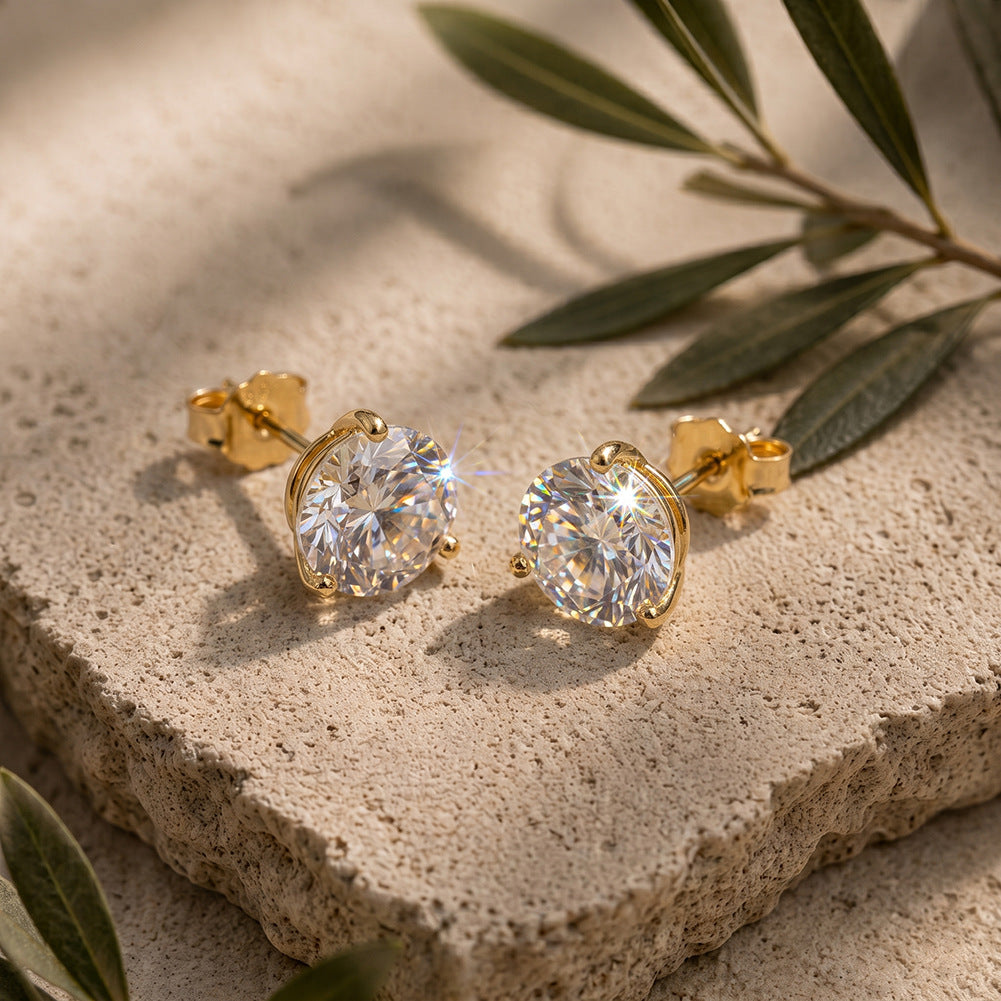 10k yellow gold 3mm round lab diamond stud earrings on natural stone surface with green leaf