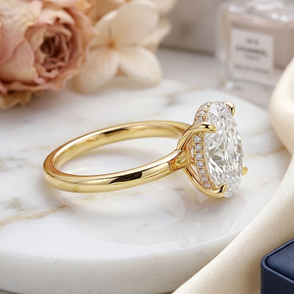 Side view profile of 10k yellow gold 2 ct oval cut lab diamond solitaire ring on white marble