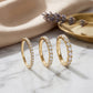 Three 10kt yellow gold round brilliant lab diamond half eternity rings displayed on white marble