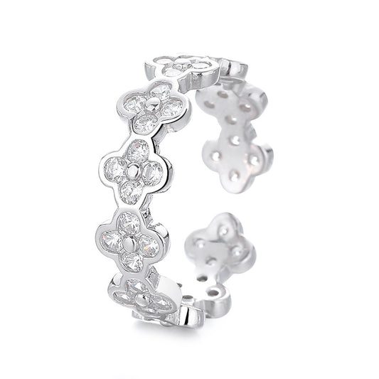 Silver floral earring with clear gemstones on a white background