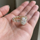 18k yellow gold oval cut lab diamond pave engagement ring resting on open palm showing top profile   