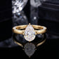 18k yellow gold pear cut lab diamond hidden halo engagement ring on black reflective surface with reflection