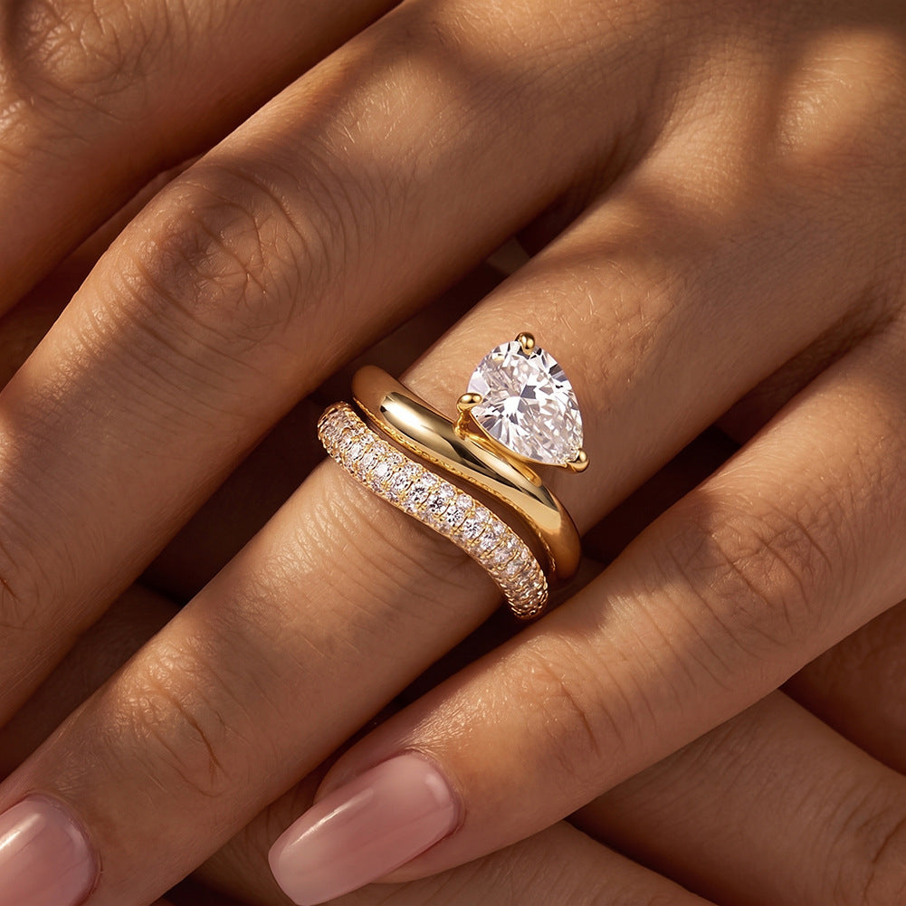 Close-up of model wearing 18k yellow gold pear shape lab diamond solitaire engagement stacking ring set   