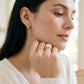 Model wearing 18k yellow gold round lab diamond six-prong engagement ring with hand near chin