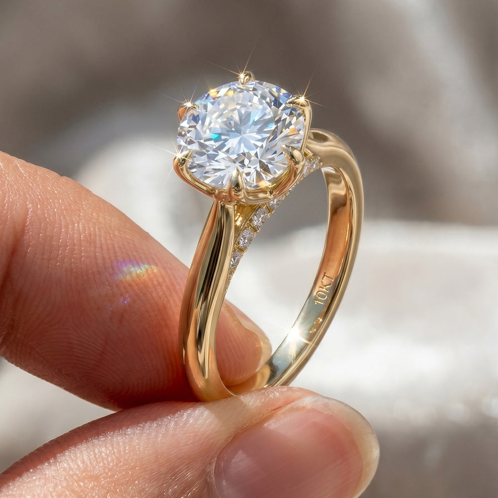 Hand holding 18k yellow gold round cut lab diamond six-prong solitaire ring showing brilliant sparkle