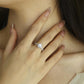Model wearing 18k yellow gold round lab diamond halo engagement ring with hand touching neck