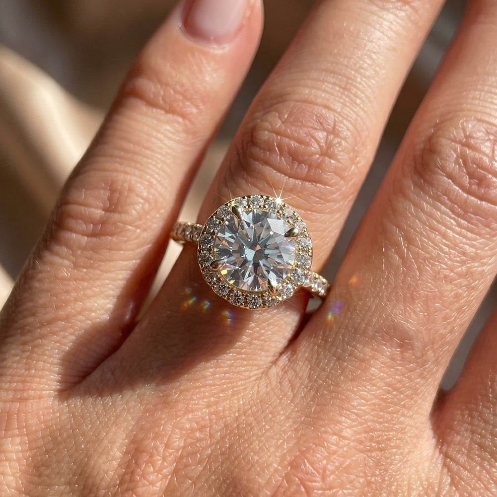 Model wearing 18k yellow gold round lab diamond halo engagement ring with pave band on hand