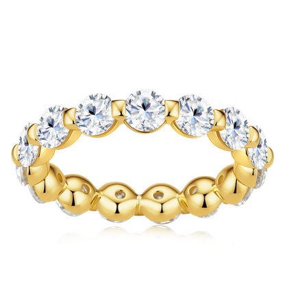 A yellow gold eternity ring featuring a row of round brilliant-cut clear gemstones on the outer band, set against a plain white background.