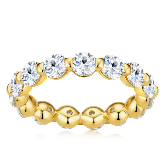 A yellow gold eternity ring featuring a row of round brilliant-cut clear gemstones on the outer band, set against a plain white background.
