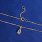 Back view of pear shape setting and spring ring clasp of 18k rose gold diamond clavicle pendant necklace