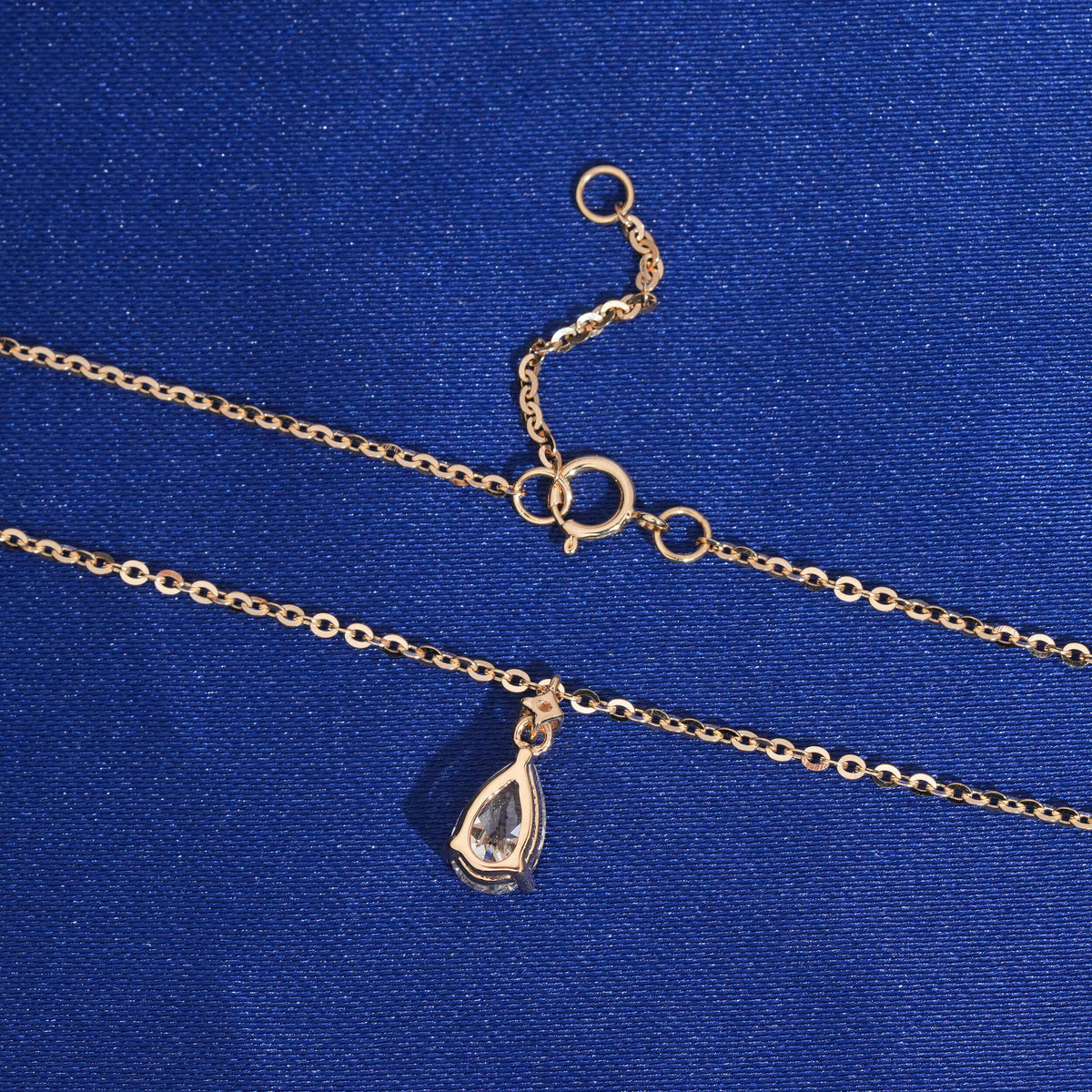 Back view of pear shape setting and spring ring clasp of 18k rose gold diamond clavicle pendant necklace