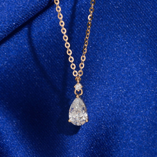 18k rose gold 1 carat pear cut lab-grown diamond clavicle pendant necklace on royal blue silk background
