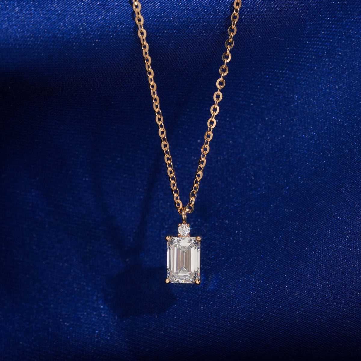 18k rose gold 1 carat radiant cut lab-grown diamond clavicle pendant necklace on royal blue silk background
