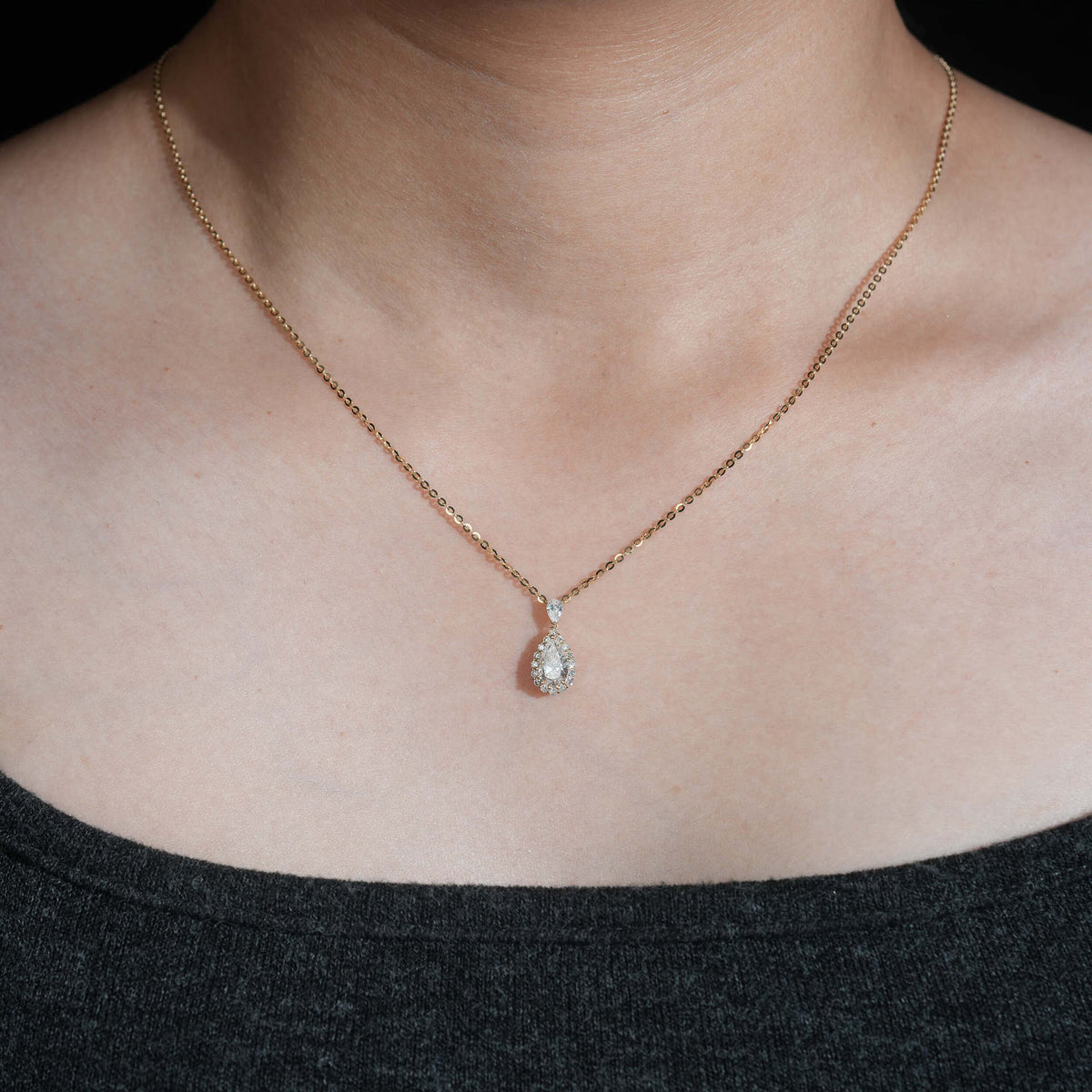 Model wearing 18k rose gold 1 ct pear halo lab-grown diamond clavicle pendant necklace   