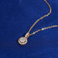 Angle view of 18k rose gold 5mm round halo lab-grown diamond clavicle pendant necklace on blue fabric