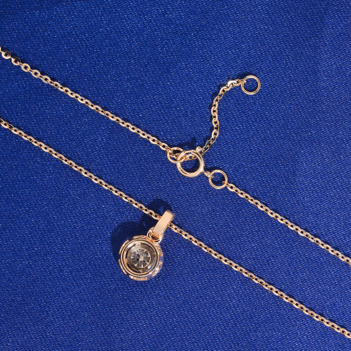 Back view of round halo setting and spring ring clasp of 18k rose gold diamond clavicle pendant necklace