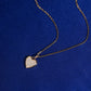 Angle view of 18k rose gold pave lab-grown diamond heart pendant necklace on blue fabric