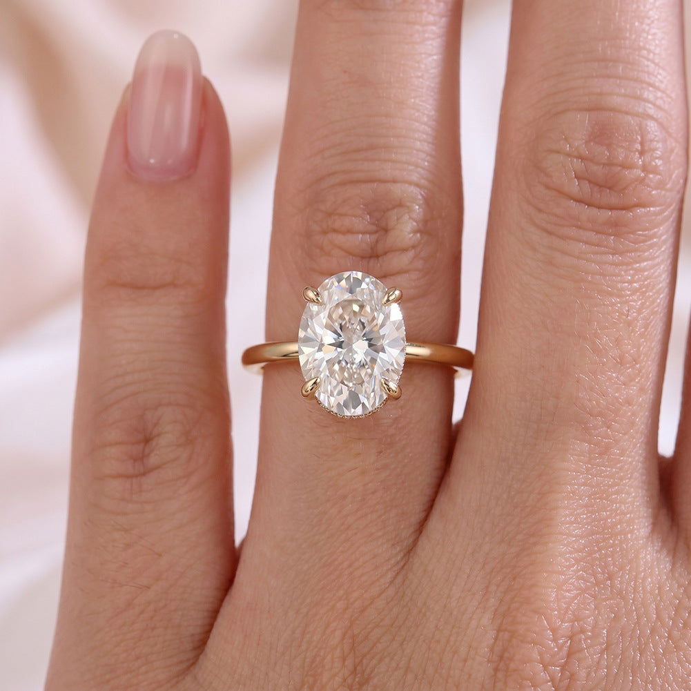 Model wearing 18k yellow gold 2 ct oval cut lab diamond solitaire engagement ring on hand