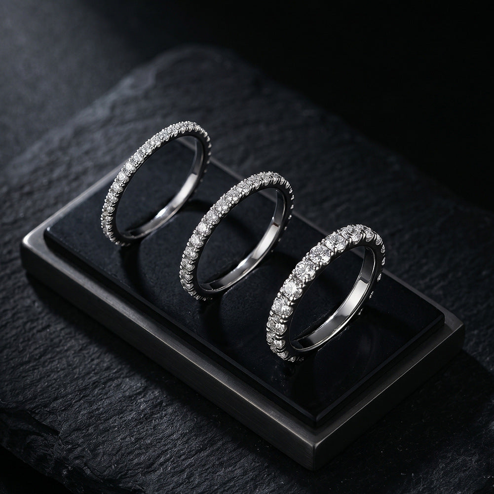 Three 18kt white gold round brilliant lab diamond half eternity rings on black velvet display pad