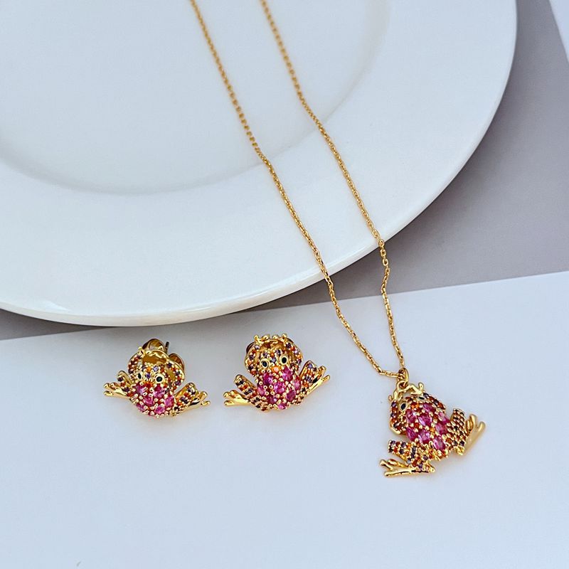 Necklace displayed on a soft green or natural-toned background, highlighting the frog pendant’s shape and crystal details. Alt: “Kate Spade Pave Frog Drop Pendant Necklace – Whimsical Crystal Animal Jewelry.”