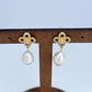 Clean, high-resolution front view of a single Tory Burch Kira Clover Pearl Drop Earring, showcasing the perfect symmetry of the clover and the pearl's glow against a pure white background.