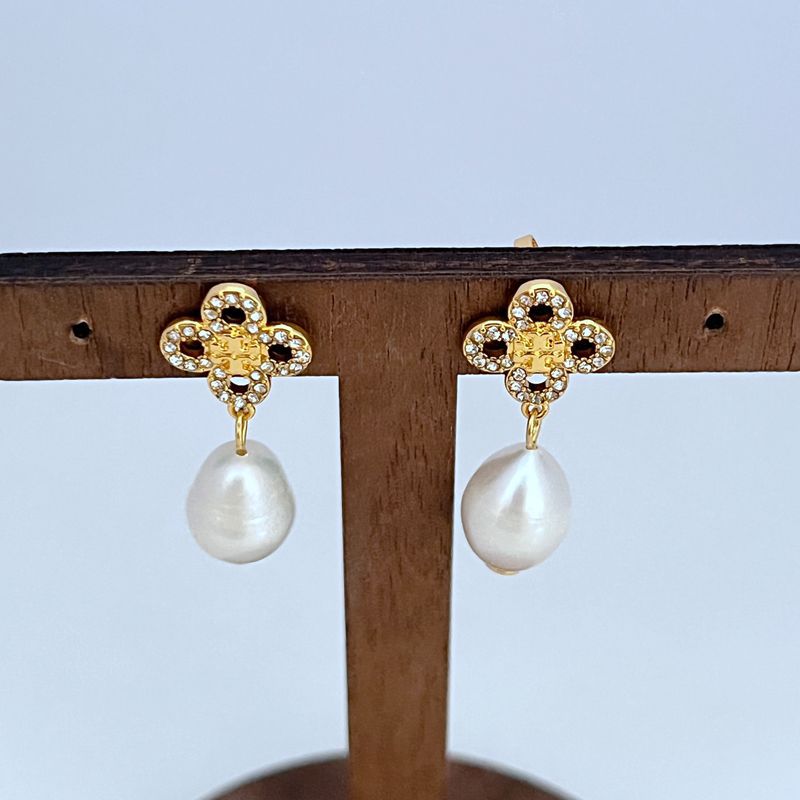 Clean, high-resolution front view of a single Tory Burch Kira Clover Pearl Drop Earring, showcasing the perfect symmetry of the clover and the pearl's glow against a pure white background.