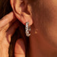 Model wearing 1CT lab grown diamond X cross cable wire huggie hoop earrings.