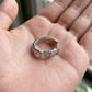 Hand holding lab grown diamond X cross cable huggie hoop showing metal engraving and size.