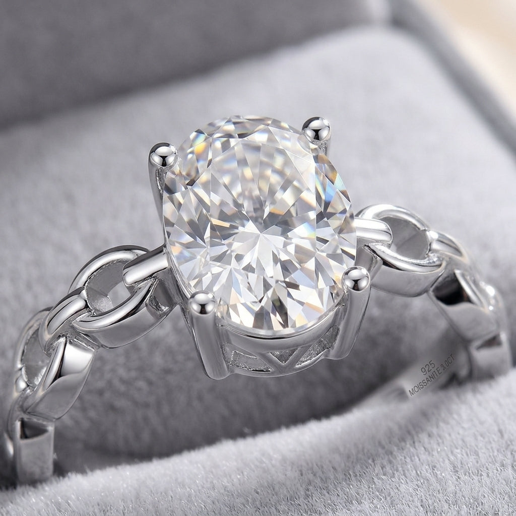 Macro view showing 4-prong basket setting and hollow interlocking chain link shank on silver moissanite ring.