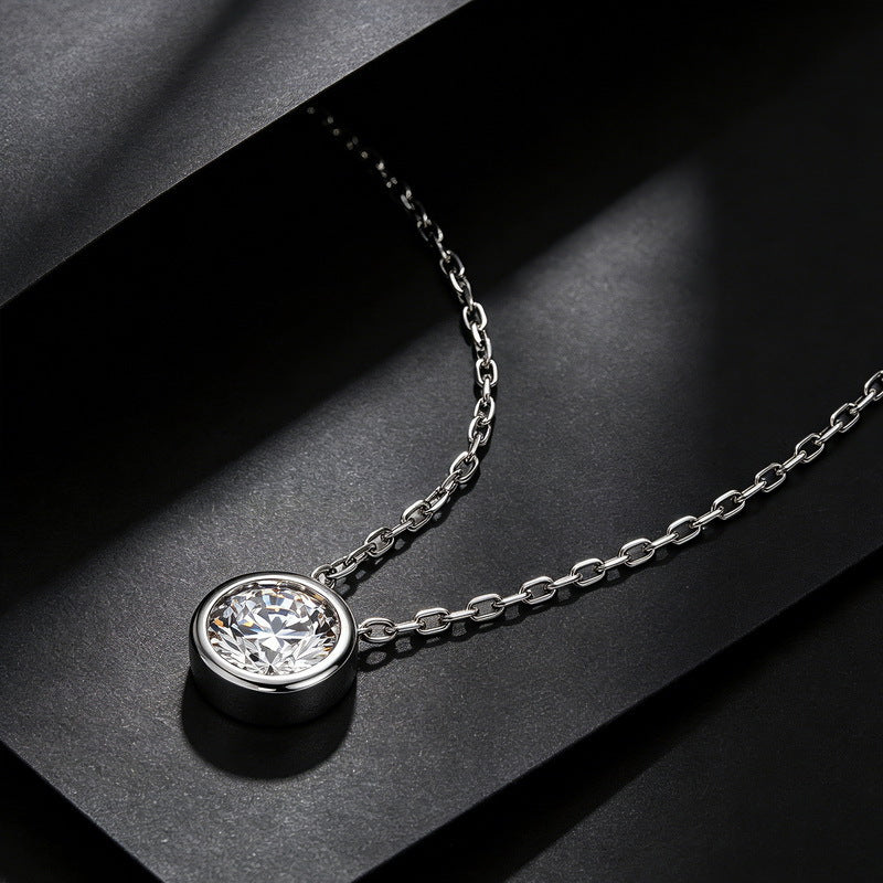 Perspective view of 1CT round bezel solitaire floating diamond pendant on black display.