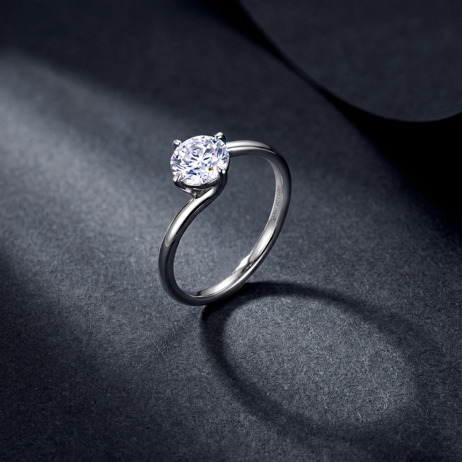 Model hands crossed close-up showing 1ct round diamond bypass solitaire engagement ring.