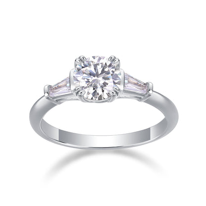 1CT round cut moissanite engagement ring with tapered baguette side stones on white background.