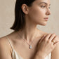 Model wearing 1ct round brilliant diamond halo pendant necklace on collarbone.