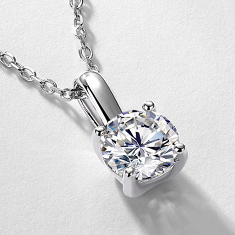 Close-up view of four-prong basket setting on 1ct round brilliant solitaire pendant.