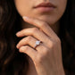 Close-up view of a model wearing 1CT round moissanite three-stone ring with tapered baguette accents.