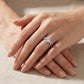 Model showing 1ct round cut moissanite crossover ring on hand in soft natural light.