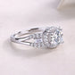Side profile view showing split shank and halo setting on silver round moissanite ring.