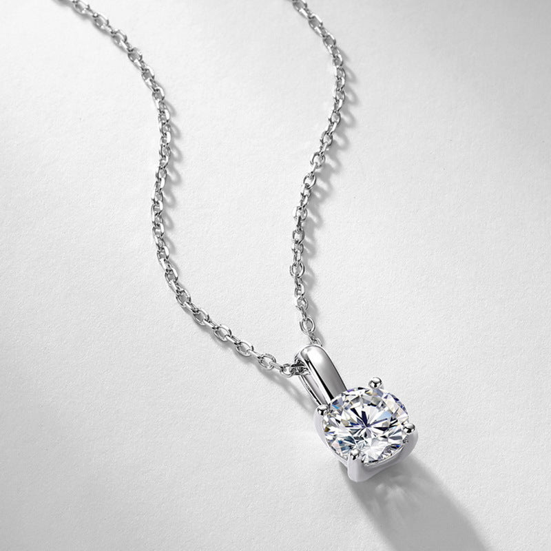 Perspective view of 1ct round solitaire pendant necklace on light gray background.