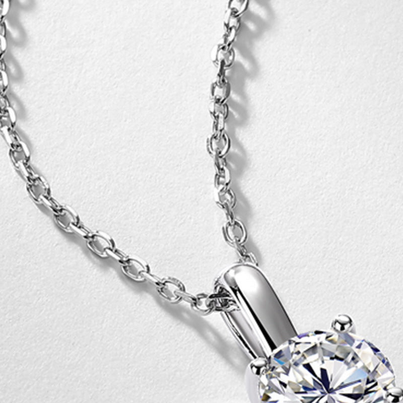 Close-up view of elegant high-bail and cable chain on 1ct round solitaire pendant.