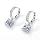 Pair of princess cut solitaire dangle huggie hoop earrings showing hinged clasp mechanism.