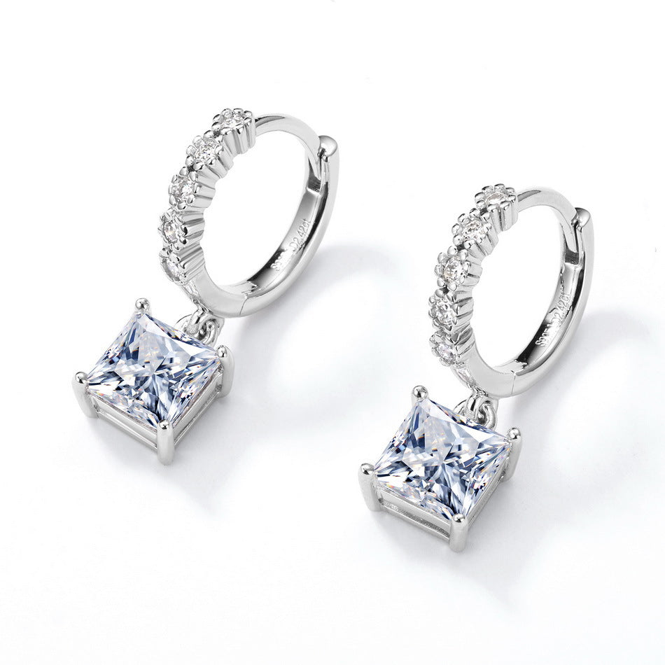 Pair of princess cut solitaire dangle huggie hoop earrings showing hinged clasp mechanism.