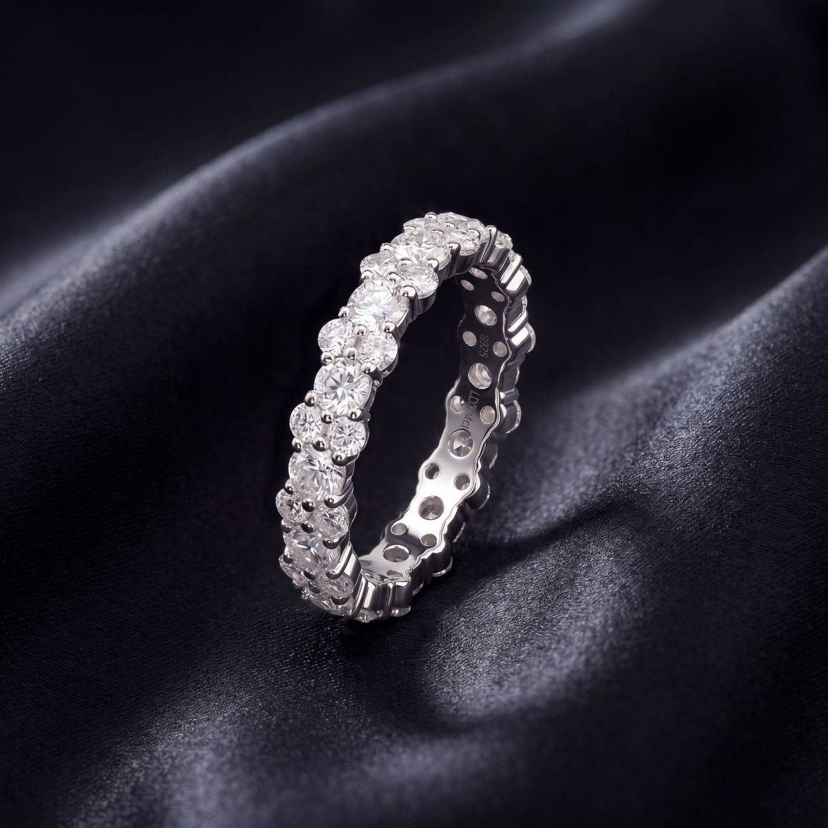 2.54ct round lab diamond alternating double row band resting on dark silk fabric.