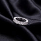 2.78 ctw pear cut lab grown diamond eternity wedding band resting flat on dark black silk