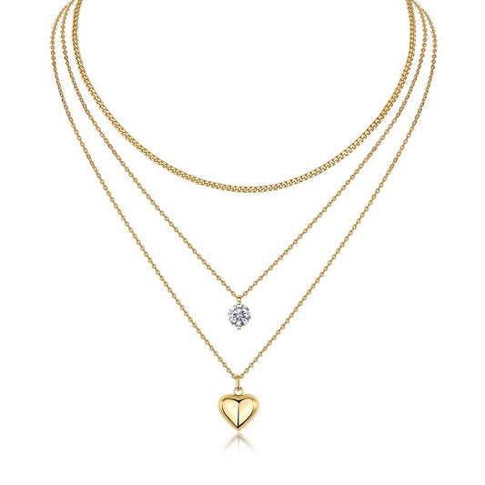 Clean white background — the 2-prong heart moissanite pendant layered with 2-3 mixed chains on a bust form. The heart-shaped stone catches light from multiple angles, showcasing the brilliant cut’s signature sparkle. The minimalist 2-prong setting keeps the heart silhouette clean and modern.