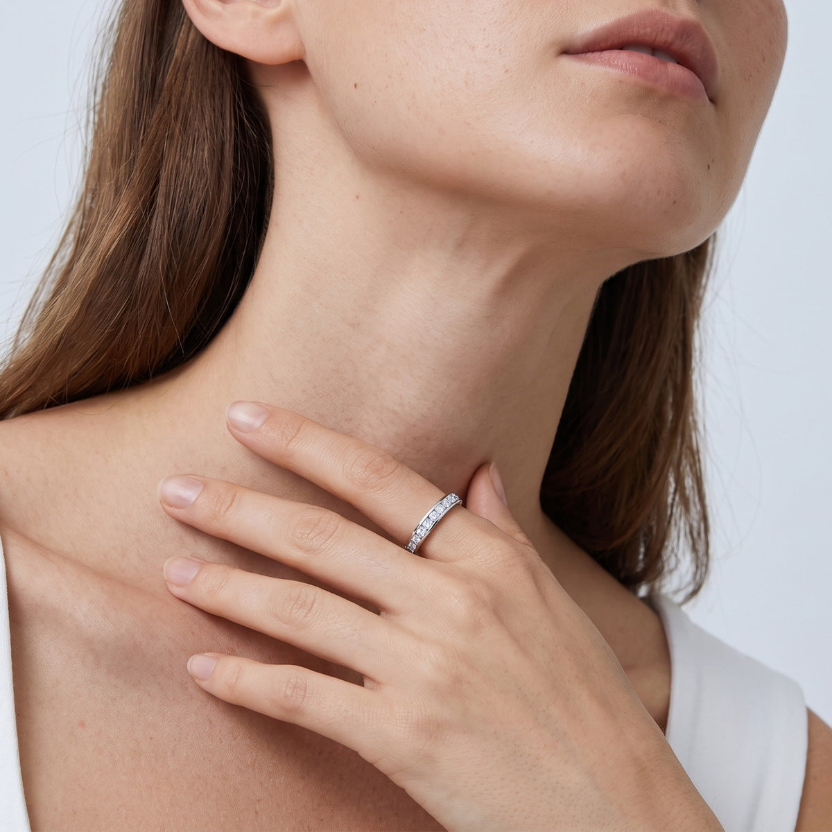 Model wearing 2 ctw channel set round lab grown diamond eternity ring on finger