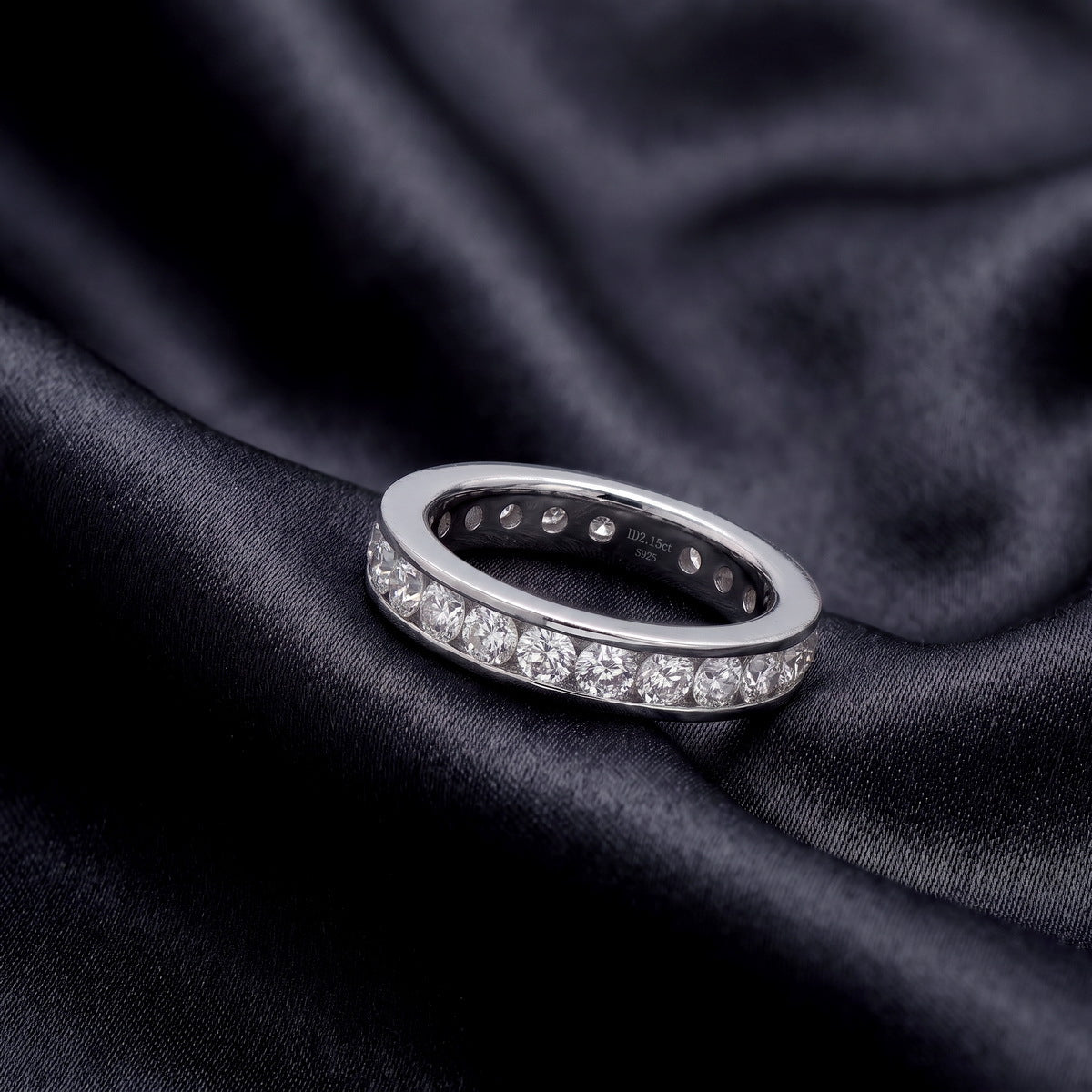 2 ctw channel set round lab grown diamond eternity wedding band resting flat on dark black silk
