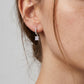Model wearing 2.42ctw princess cut dangle huggie earrings with scalloped pavé hoops.